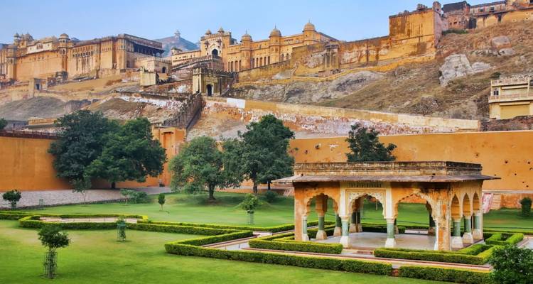 Amber Fort and manicured gardens rising above green lawns and walls.
