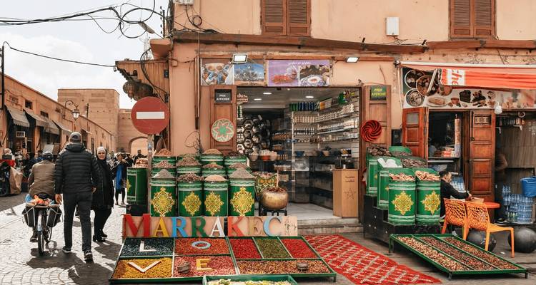 Tienda colorida de especias y frutas secas en Marrakech mostrando un gran letrero de 'Marrakech Love'