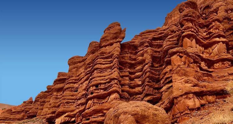 Formaciones rocosas dramáticas de arenisca estratificada conocidas como Dedos de Mono se alzan contra un cielo despejado