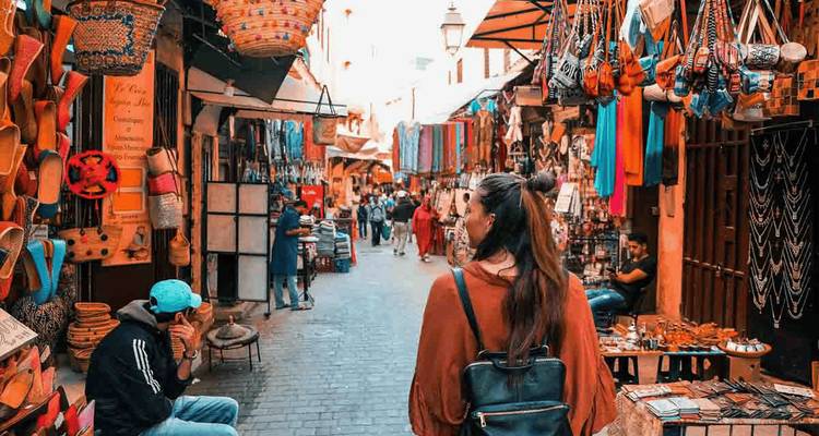 Female traveler wanders through a vibrant Moroccan souk lined with crafts and textiles