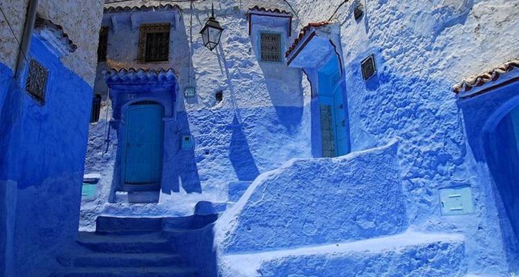 Narrow alley of vivid blue-painted walls, doors and steps in a Moroccan medina.