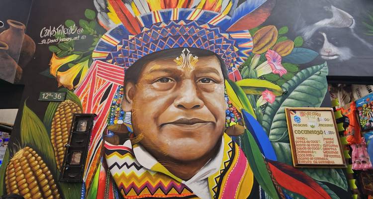 Murale de rue aux thèmes autochtones vibrants débordant de couleurs, de plumes et de motifs dans le quartier La Candelaria de Bogotá.
