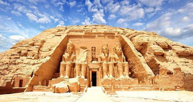Majestic rock-cut temple of Abu Simbel with colossal seated statues under dramatic sky