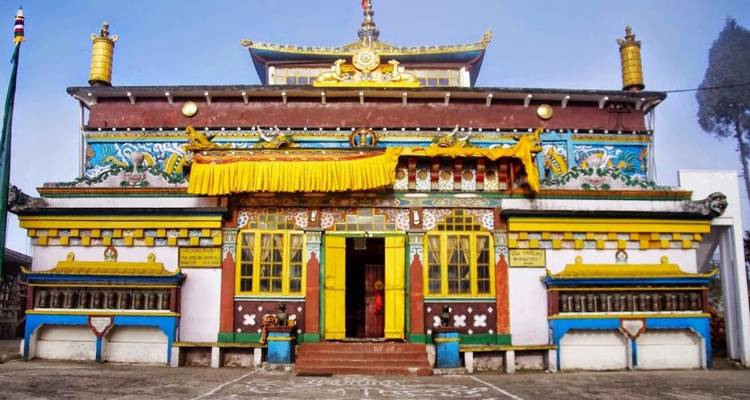 Brightly painted Buddhist monastery facade with yellow drapery and intricate murals