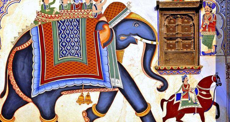 Vibrant Rajasthani fresco showing an elephant carrying nobles, alongside detailed door carvings.
