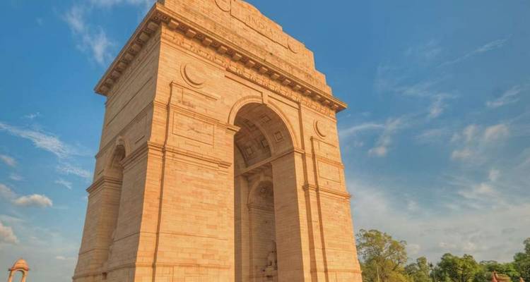 India Gate war memorial bathed in warm afternoon light against clear sky