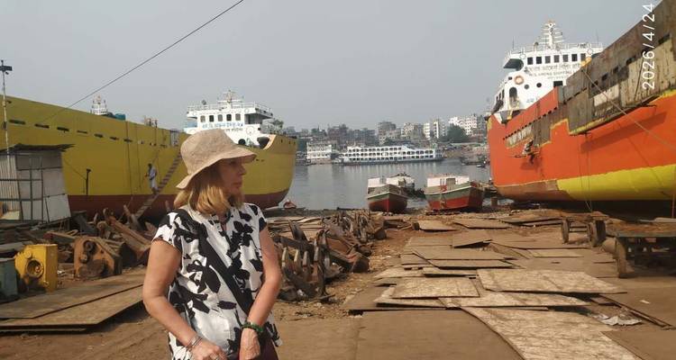 Un visiteur explore un chantier naval riverain animé avec des navires aux couleurs vives en cale sèche