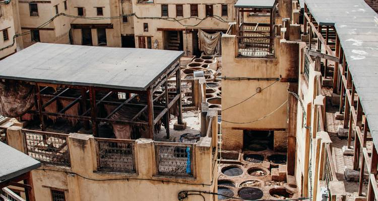 Uitzicht naar beneden op oude stenen vaten van een traditioneel looierij complex in Fes.