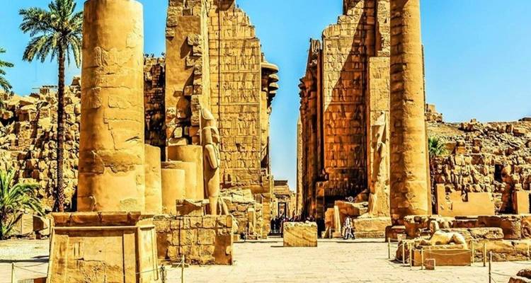 Grand entrance lined with massive sandstone columns and statues at Karnak Temple
