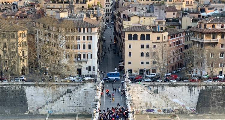 Vue surélevée d'un pont rempli de personnes menant aux rues historiques de Rome.