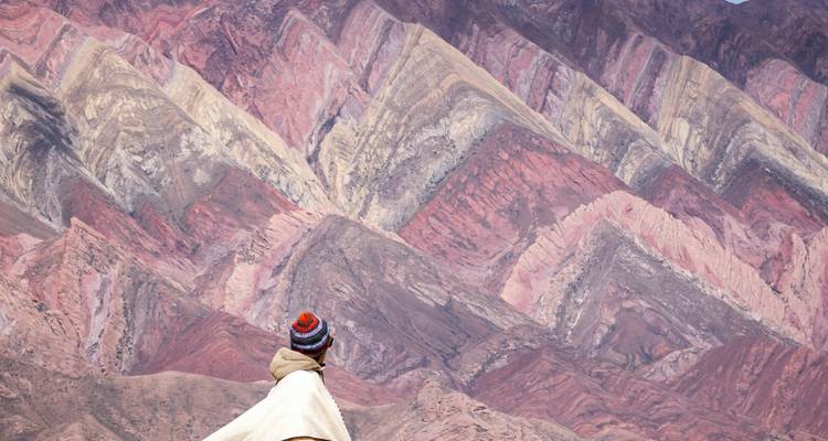 Traveler with colorful hat admires the multicolored layers of Cerro de los Catorce Colores.