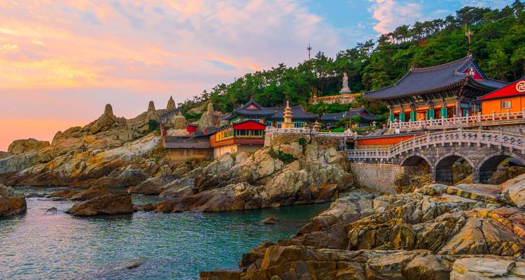 Haedong Yonggungsa temple and rocky coastline at colorful sunrise in Busan