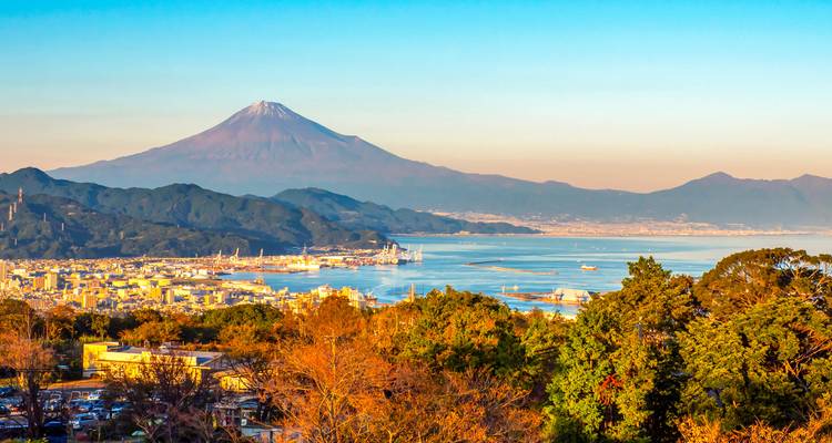 Mount Fuji rising over coastal city and bay in clear morning light