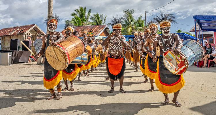 Traditional Papua New Guinea drummers in colorful tribal attire performing parade