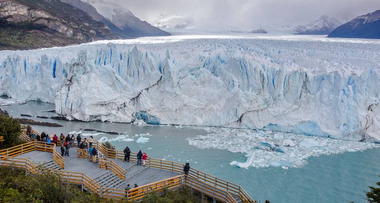 Vista panorámica expansiva del Glaciar Perito Moreno de color turquesa con pasarelas de madera llenas de turistas.