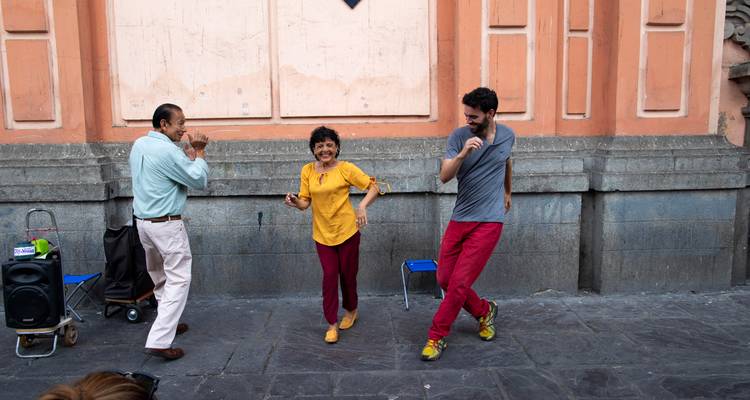 Een trio dansers barst midden tijdens de voorstelling in lachen uit tegen een oude stucmuur in het centrum van Lima.