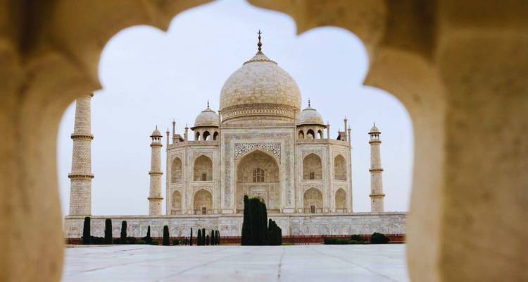 Iconic view of the Taj Mahal framed by an archway, its marble glowing softly.