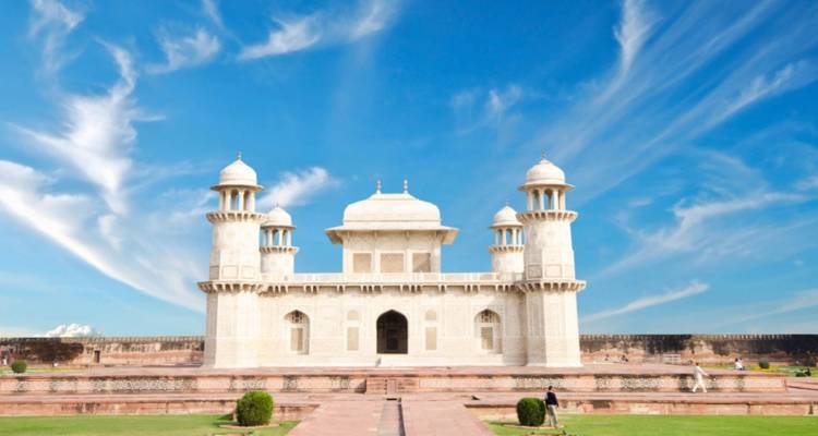 The white marble Itimad-ud-Daulah Tomb stands against a vivid blue sky with wispy clouds.