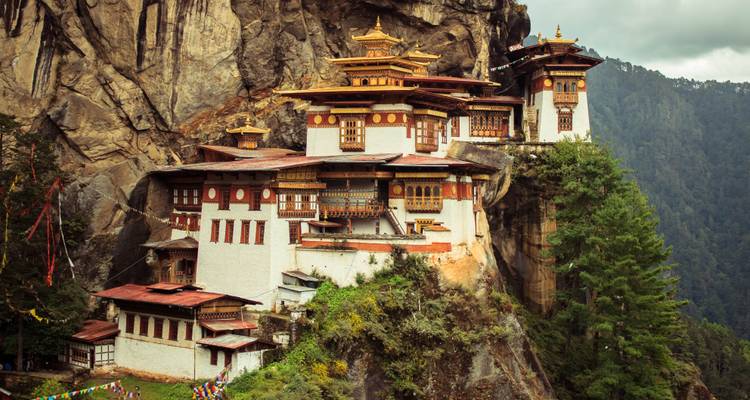 Repeat view of Tiger’s Nest Monastery perched on a cliff in verdant forest.