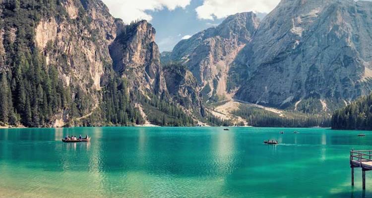 Turquoise wateren van Lago di Braies omringd door steile, met dennen begroeide rotswanden en imposante Dolomiten.
