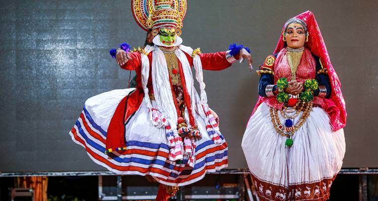Traditional Kathakali dancers in elaborate costumes and makeup performing on stage