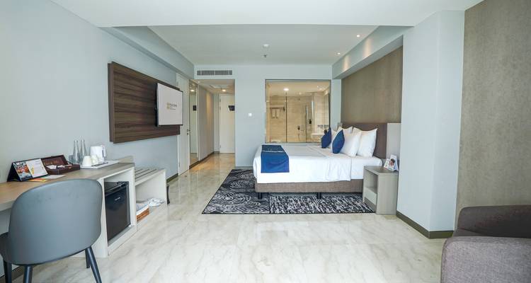 Modernes geräumiges Hotelzimmer mit Kingsize-Bett, Schreibtisch und Marmorböden.