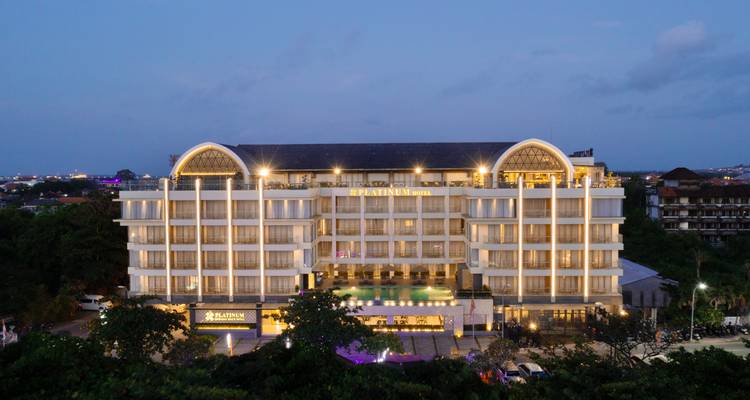 Nächtliche Außenansicht eines hell beleuchteten modernen Hotelgebäudes.