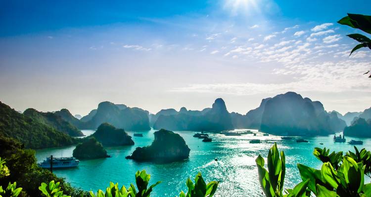 Spektakuläre Panoramaaussicht auf die smaragdgrünen Gewässer und Kalksteinkarstformationen der Halong-Bucht unter strahlender Sonne.