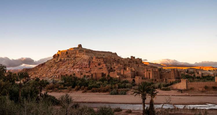 Historische befestigte Ksar von Ait Benhaddou, die im warmen Abendlicht über einem trockenen Fluss erstrahlt