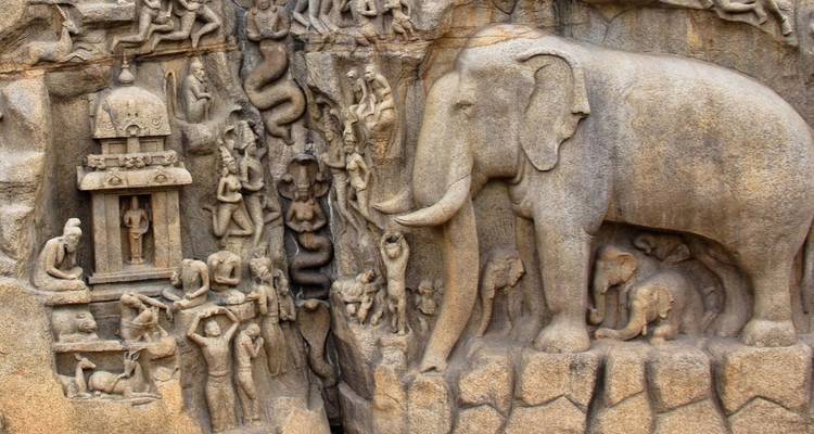 Intricate stone bas-relief depicting elephants and mythological figures carved into a cliff face.