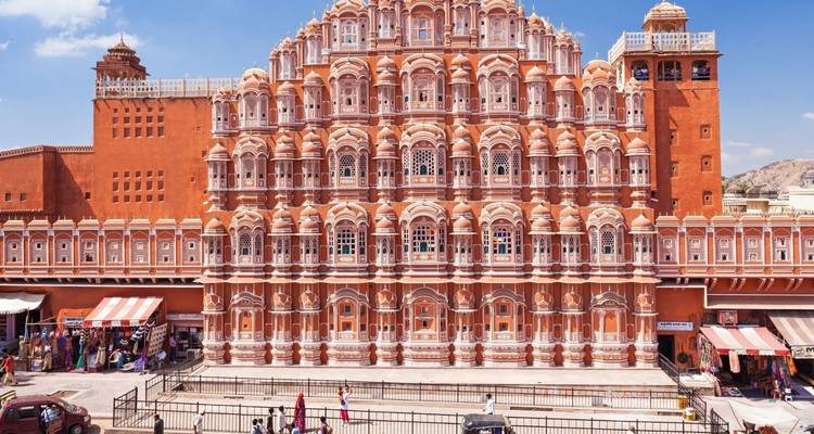 The ornate pink sandstone façade of Hawa Mahal towers above busy street life