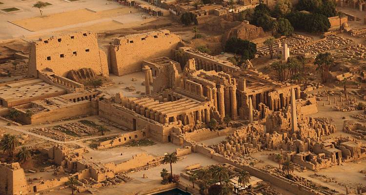 Luftaufnahme bei Sonnenuntergang des weitläufigen Karnak-Tempelkomplexes mit seinen massiven Pylonen und Innenhöfen.