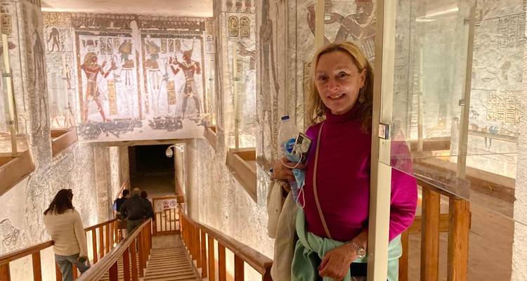 Bezoeker die staat in een rijk beschilderd oud-Egyptisch graf dat bereikbaar is via een houten trap