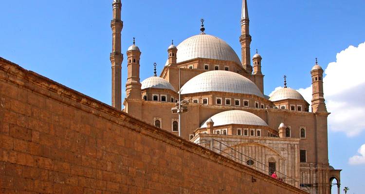 The elegant domes and minarets of the Muhammad Ali Mosque rising against a clear blue sky.