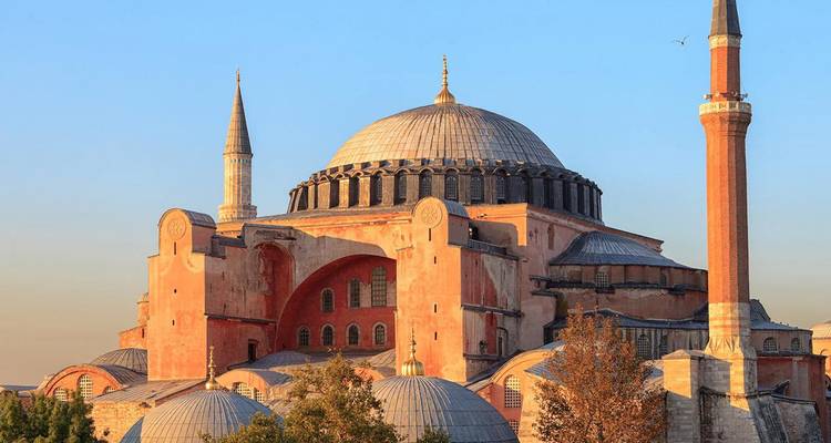 Iconic Hagia Sophia with soaring minarets and warm evening light against a blue sky.