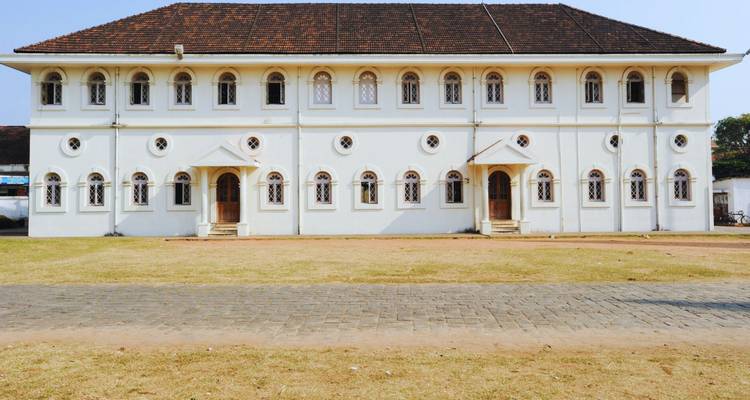 White colonial-era synagogue building with arched windows in Fort Kochi