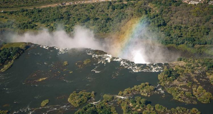 Arc-en-ciel se formant au-dessus du sommet brumeux des chutes Victoria vues d'en haut