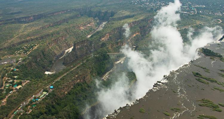Vue aérienne des chutes Victoria avec un épais brouillard blanc s'élevant haut au-dessus de la gorge