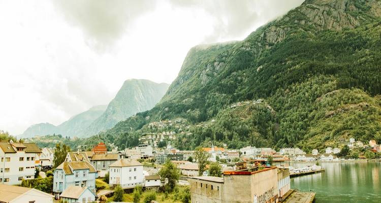 Petite ville nichée entre des montagnes verdoyantes et un fjord sous une lumière douce