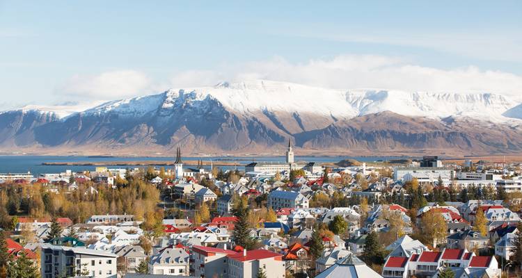 Vue aérienne des toits colorés de Reykjavik avec les montagnes enneigées et la baie au-delà