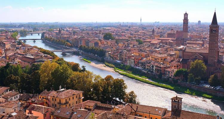 Panorama der historischen Skyline Veronas mit dem sich durch terrakottafarbene Dächer und Kirchtürme windenden Fluss Adige