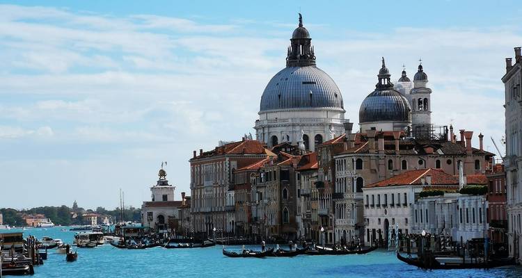 Klassische Venedig-Skyline mit den Kuppeln der Santa Maria della Salute und Gondeln auf der hell leuchtenden Lagune