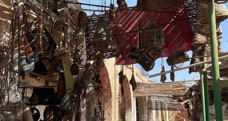 Dimly lit alley shop with hanging metal lanterns and crafts creating intricate shadows.