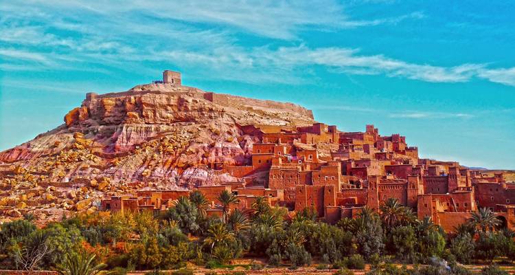 Vista llena de color de los edificios de barro de Ait Benhaddou contra un cielo azul vivido.