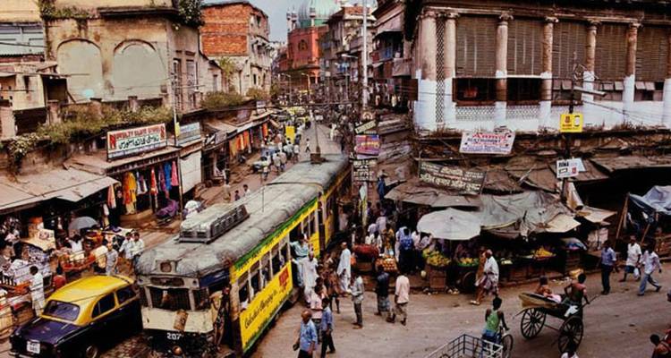 Bustling Kolkata street scene with a vintage tram, vendors and colorful chaos.