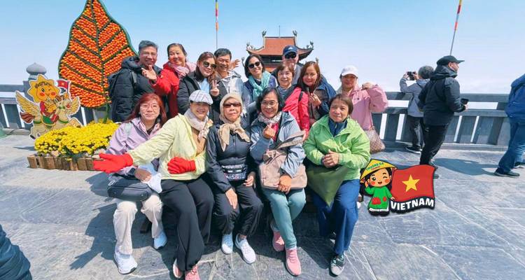 Tour group posing at summit terrace with cartoon Vietnam flag overlay.