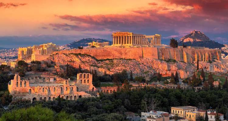 Un coucher de soleil dramatique projette une lueur chaleureuse sur l'Acropole et la ligne d'horizon d'Athènes avec des nuages roses.