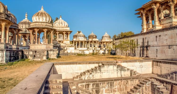 Rangée de dômes en marbre et de piliers de cénotaphe sous un ciel bleu clair sur le site commémoratif historique.