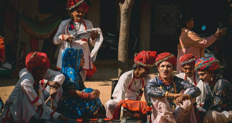 Rajasthani-Volksmusiker und Tänzer in farbenfrohen Turbanen und Trachten, die sich zwischen den Auftritten ausruhen.