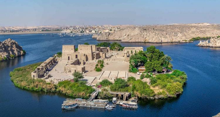 Aerial view of Philae Temple complex on an island surrounded by deep blue Nile waters.